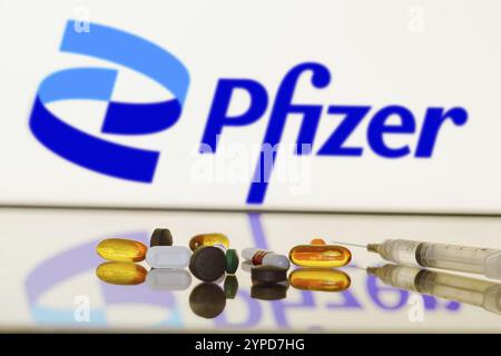 27 mai 2024, Brésil. Dans cette illustration photo, le logo de Pfizer est affiché à l'écran en arrière-plan avec des pilules et un flacon médical et une seringue Banque D'Images
