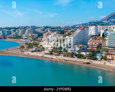 Vue aérienne de Benalmadena, Espagne, avec un bâtiment en forme de pyramide avec un toit rouge, des plages de sable, des palmiers et des gratte-ciel modernes. Banque D'Images