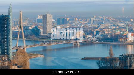 Vue aérienne de Riga, Lettonie, avec la rivière Daugava et le pont Vansu. L'horizon comprend des gratte-ciel modernes et une flèche d'église dans la vieille ville. Banque D'Images