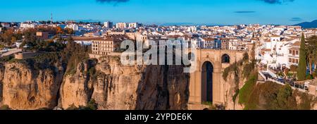 Ronda, Espagne, présente le pont Puente Nuevo sur la gorge El Tajo, avec des bâtiments blanchis à la chaux et des rues étroites illuminées par le soleil couchant. Banque D'Images