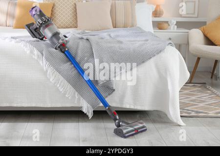 Un aspirateur sans fil reposant sur le lit à l'intérieur Banque D'Images