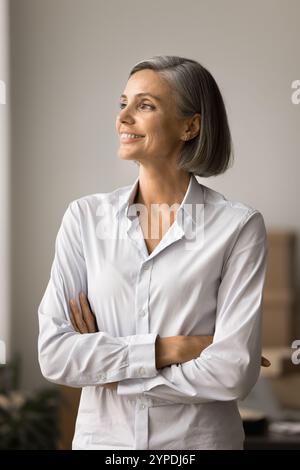 Portrait vertical de femme d'affaires mature rêveuse heureuse Banque D'Images