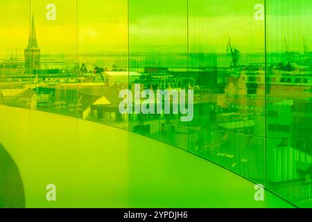 Vue intérieure des sections jaunes et vertes de la passerelle arc-en-ciel du musée d'art ARoS Aarhus, offrant un paysage urbain déformé et flou à travers l'étain Banque D'Images