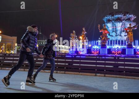 Moscou, Russie. 29 novembre 2024. Les gens patinent sur une patinoire à l'exposition des réalisations de l'économie nationale (VDNH) à Moscou, Russie, le 29 novembre 2024. La patinoire extérieure du VDNH a ouvert au public vendredi. Crédit : Alexander Zemlianichenko Jr/Xinhua/Alamy Live News Banque D'Images