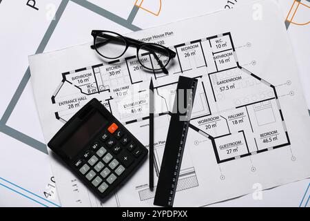 Verres, calculatrice et règle sur différents dessins architecturaux, pose à plat Banque D'Images
