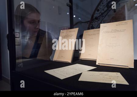 Londres, Royaume-Uni. 29 novembre 2024. LONDRES, ROYAUME-UNI - 29 NOVEMBRE 2024 : un membre de l'équipe examine la première édition exceptionnellement rare, les numéros de l'auteur, des articles lauréats du prix Nobel d'Einstein, de la bibliothèque du physicien théoricien pionnier Arnold Sommerfeld (estimation £70,000-100,000) lors d'un appel photo à la maison de vente aux enchères Christie's avant les ventes de la semaine classique à Londres, Royaume-Uni, le 29 novembre 2024. (Photo de Wiktor Szymanowicz/NurPhoto) crédit : NurPhoto SRL/Alamy Live News Banque D'Images