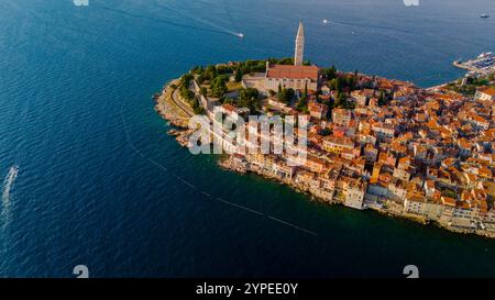 La ville pittoresque de Rovinj prend vie lorsque le soleil se lève sur l'Adriatique, illuminant ses bâtiments colorés, son église ancienne et ses eaux vibrantes, offrant une vue imprenable pour les lève-tôt. Banque D'Images