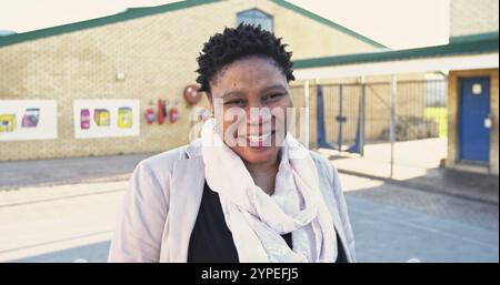 Portrait en gros plan d'une enseignante africaine d'âge moyen avec les cheveux pointus courts tournant et l Banque D'Images