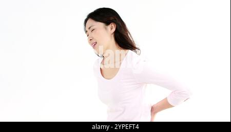 Jolie femme asiatique avec mal d'estomac sur écran blanc Banque D'Images