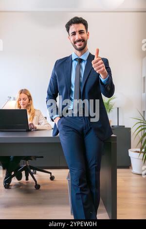 Homme d'affaires confiant souriant et donnant les pouces vers le haut geste en costume. Vertical Banque D'Images