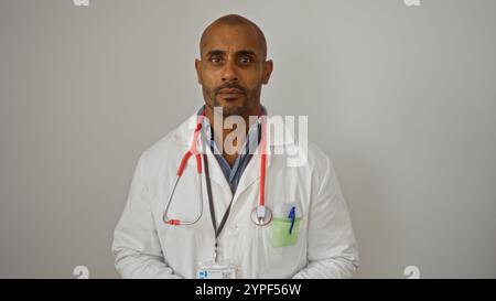 Médecin afro-américain portant un manteau blanc avec un stéthoscope rouge debout sur un fond blanc Banque D'Images