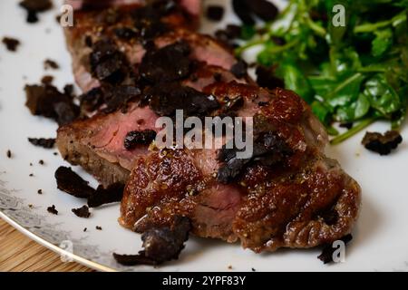 Tagliata di Manzo al Tartufo bœuf tranché avec truffes servi avec une salade de roquette verte ou d'Arugula Banque D'Images