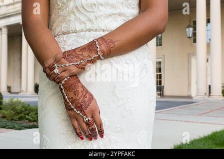 Gros plan des mains de la mariée indienne en robe blanche montrant des motifs complexes de henné Banque D'Images