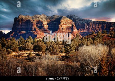 Courthouse Rock à Sedona est majestueux, ses murs de grès rouge illuminés par la douce lueur dorée du soleil du matin après une récente tempête de neige. Banque D'Images