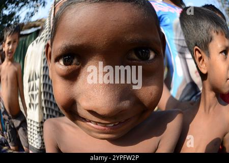 Des enfants bengalis s'amusent avec la caméra dans un bidonville en bord de route à Dhaka, au Bangladesh. Banque D'Images