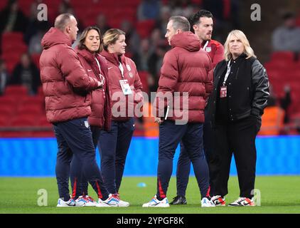 La manager américaine Emma Hayes (à droite) et le personnel inspectent le terrain avant un match amical international au stade de Wembley, à Londres. Date de la photo : samedi 30 novembre 2024. Banque D'Images