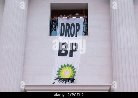 Londres, Royaume-Uni. 30 novembre 2024. Une bannière géante déclarant « Drop BP » est accrochée au balcon de la Grande Cour du British Museum alors que des militants écologistes du Climate Choir Movement mettent en scène une performance non autorisée de chansons appelant à la fin de l'accord de parrainage avec BP. Le musée a signé un accord de 50 millions de livres sterling avec BP en 2023 et les activistes accusent le musée de «greenwash» la réputation du géant pétrolier britannique. BP a récemment réduit son engagement à réduire sa production de pétrole et de gaz et à accroître ses investissements dans les énergies renouvelables. Crédit : Ron Fassbender/Alamy Live News Banque D'Images