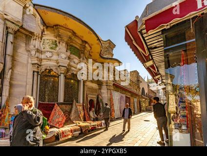 Istanbul, TR - 23 octobre 2024 rue animée à l'extérieur du Grand Bazar : les commerçants appellent, des marchandises colorées sont exposées et les acheteurs marchandent avec impatience au milieu Banque D'Images