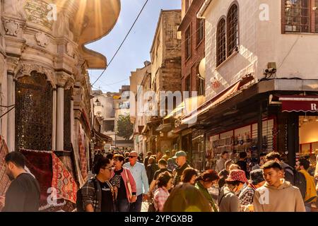 Istanbul, TR - 23 octobre 2024 rue animée à l'extérieur du Grand Bazar : les commerçants appellent, des marchandises colorées sont exposées et les acheteurs marchandent avec impatience au milieu Banque D'Images