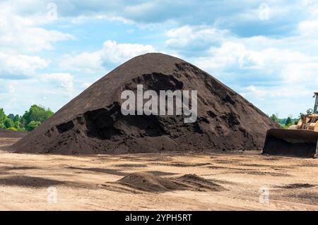 Tas de compost, fabriqués à partir de fumier de vache, retournés et empilés dans une usine de production dans le Michigan, États-Unis. Banque D'Images