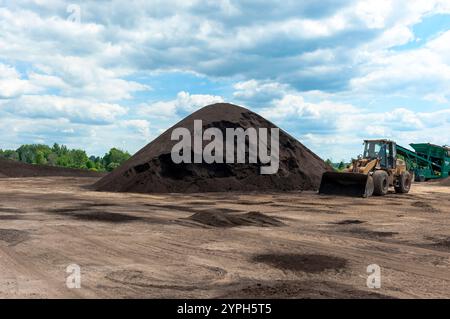 Tas de compost, fabriqués à partir de fumier de vache, retournés et empilés dans une usine de production dans le Michigan, États-Unis. Banque D'Images