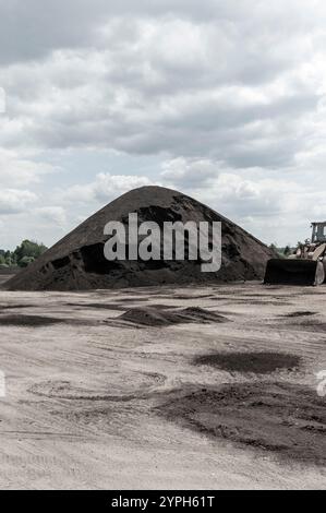 Tas de compost, fabriqués à partir de fumier de vache, retournés et empilés dans une usine de production dans le Michigan, États-Unis. Banque D'Images