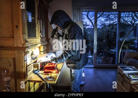 Image symbolique d'un cambriolage, l'auteur a pénétré dans un appartement du côté du jardin et est à la recherche de butin, ordinateur, ordinateur portable, objets de valeur, argent, tec Banque D'Images
