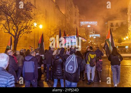 Logroño, la Rioja, Espagne. Vendredi 30 novembre 2024. Manifestation de RESCOP, réseau de solidarité contre l’occupation de la Palestine, dans les rues de Logroño. Les manifestants utilisent des bidons de fumée et des instruments à percussion pour attirer l'attention et perturber la normalité urbaine. Leur but est d'attirer l'attention sur le conflit de Gaza, en dénonçant ce qu'ils considèrent comme un génocide contre le peuple palestinien. L’intervention de rue devient un espace d’expression collective, défiant l’indifférence et exigeant une réponse internationale à la crise palestinienne. Crédit : Mario Martija/Alamy Live News. Banque D'Images