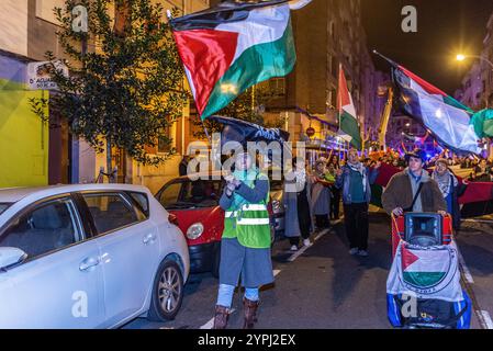 Logroño, la Rioja, Espagne. Vendredi 30 novembre 2024. Manifestation de RESCOP, réseau de solidarité contre l’occupation de la Palestine, dans les rues de Logroño. Les manifestants utilisent des bidons de fumée et des instruments à percussion pour attirer l'attention et perturber la normalité urbaine. Leur but est d'attirer l'attention sur le conflit de Gaza, en dénonçant ce qu'ils considèrent comme un génocide contre le peuple palestinien. L’intervention de rue devient un espace d’expression collective, défiant l’indifférence et exigeant une réponse internationale à la crise palestinienne. Crédit : Mario Martija/Alamy Live News. Banque D'Images