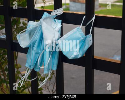 Masques médicaux jetables suspendus à une clôture Banque D'Images