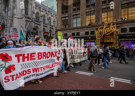 New York, New York, États-Unis. 29 novembre 2024. Des centaines de personnes défilent devant Saks Fifth Avenue pour exiger la fin des massacres de Palestiniens perpétrés par Israël lors de la Journée internationale de solidarité avec le peuple palestinien. Des manifestations ont eu lieu dans des dizaines de villes à travers le monde, notamment Los Angeles, Chicago et Denver, entre autres grandes villes américaines. (Crédit image : © Michael Nigro/Pacific Press via ZUMA Press Wire) USAGE ÉDITORIAL SEULEMENT! Non destiné à UN USAGE commercial ! Banque D'Images