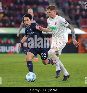 Augsbourg, Allemagne. 30 novembre 2024. Kristijan Jakic (R) du FC Augsburg affronte Miyoshi Koji du VfL Bochum lors du match de première division de la Bundesliga entre le FC Augsburg et le VfL Bochum à Augsbourg, en Allemagne, le 30 novembre 2024. Crédit : Philippe Ruiz/Xinhua/Alamy Live News Banque D'Images