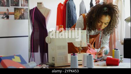 Vue avant de créatrice de mode afro-américaine regardant des échantillons de tissu dans l'atelier Banque D'Images