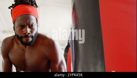 Boxeur masculin concentré pratiquant la boxe dans un studio de fitness Banque D'Images