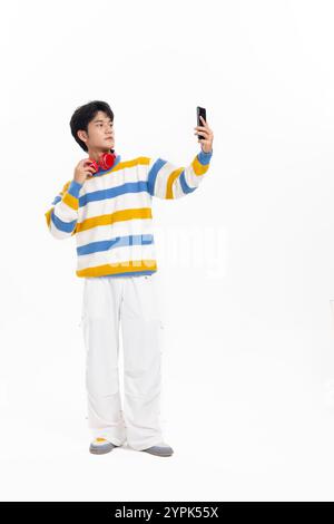 Un jeune homme asiatique portant des écouteurs rouges Banque D'Images