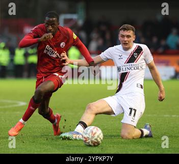 Ade Adeyemo de Crawley Town est défié par Ethan Hamilton de Lincoln City lors du match de 2e tour de la FA Cup entre Crawley Town et Lincoln City au Broadfield Stadium de Crawley. Banque D'Images