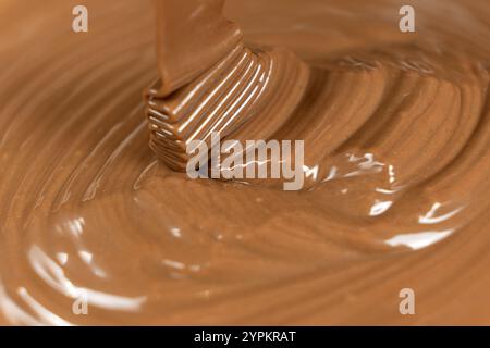 Flux de chocolat liquide au lait fondu, gros plan. Banque D'Images