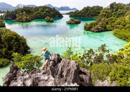 Femme touriste sur une colline rocheuse au spectaculaire lagon idyllique entouré d'îles karstiques dans l'archipel Sombori, Sulawesi, Indonésie Banque D'Images