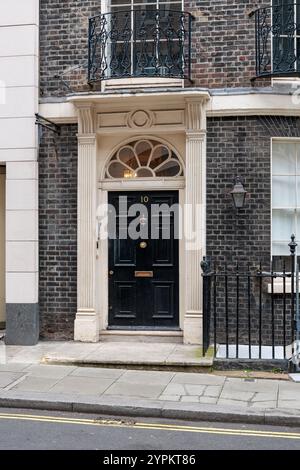 Maison historique londonienne avec élégante porte noire numéro 10, à l'architecture géorgienne avec lumière de ventilateur et porte en pierre ornée Banque D'Images