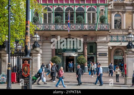 Entrée ornée du Clermont Hotel London, balcon victorien en ferronnerie, lampadaires décoratifs et piétons animés Banque D'Images