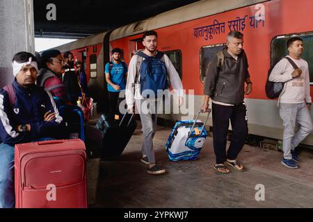 Voyageurs ferroviaires sur un quai de chemin de fer, arrivant juste à la gare de Dadar à Mumbai, Inde ; à gauche : un passager masculin attendant avec sa valise Banque D'Images