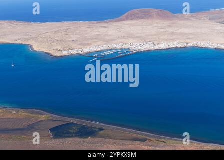 L'île de la Graciosa dans les îles Canaries et la ville principale de Caleto Del Sebo avec la montagne volcanique en arrière-plan, vue de Lanzarote. Banque D'Images