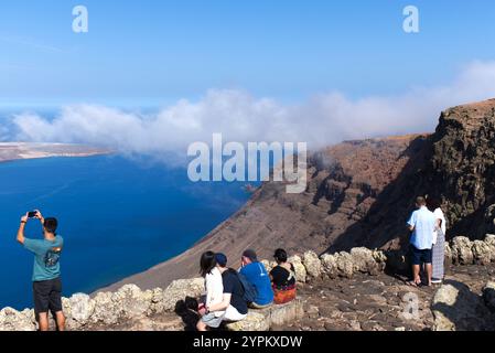 Touristes appréciant le point de vue du Mirador Del Rio sur Lanzarote de l'île de la Graciosa dans les îles Canaries et les falaises spectaculaires. Banque D'Images