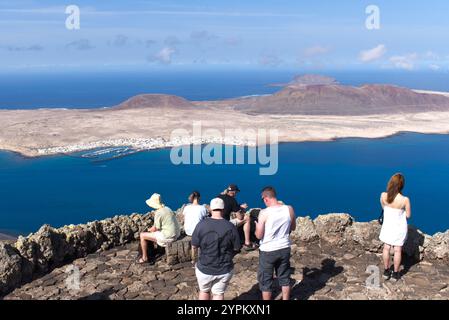 Vue sur l'île de la Graciosa dans les îles Canaries et la ville principale de Caleto Del Sebo avec les touristes regardant du Mirador Del Rio sur Lanzarote. Banque D'Images