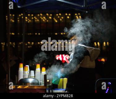 Sofia, Bulgarie, novembre 27 2024 : un vendeur de maïs au marché de Noël la nuit Banque D'Images