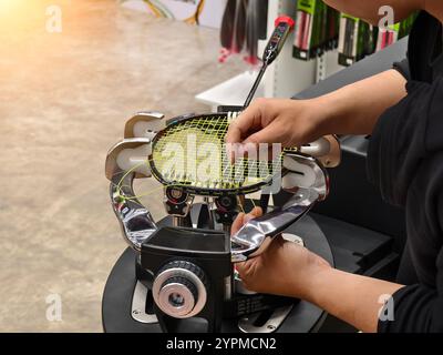 Cordes une raquette de badminton sur une machine à cordes de raquettes. Banque D'Images