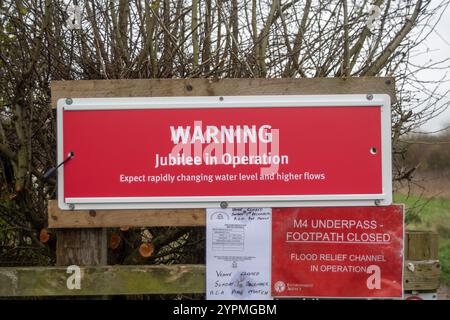 Taplow, Royaume-Uni. 30 novembre 2024. Suite aux fortes pluies qui ont frappé la tempête Bert plus tôt dans la semaine, le système Jubilee River Flood relief (atténuation des inondations de la rivière Jubilee) est actuellement en vigueur afin de stopper les inondations à Windsor & Eton, dans le Berkshire. Les panneaux d'avertissement indiquent aux gens de s'attendre à une évolution rapide des niveaux d'eau et à des débits plus élevés. Crédit : Maureen McLean/Alamy Live News Banque D'Images