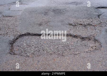 Taplow, Royaume-Uni. 30 novembre 2024. Les nids de poule sont réapparus à Marsh Lane, Taplow, Buckinghamshire. Certains automobilistes font un virage pour les éviter. Les réparations des nids-de-poule précédents sur ce tronçon de route ont été effectuées en mai 2023 par des entrepreneurs du conseil municipal du Buckinghamshire qui ont utilisé un nouveau système Velocity Patching pour remplir les milliers de nids-de-poule à travers Bucks. Le patcher Velocity force l'air à grande vitesse dans les nids de poule pour les éliminer, puis la zone est enduite de bitume froid pour créer un joint, avant que l'agrégat ne soit enduit de bitume et appliqué, à nouveau à grande vitesse. Les réparations n'ont cependant pas été effectuées Banque D'Images