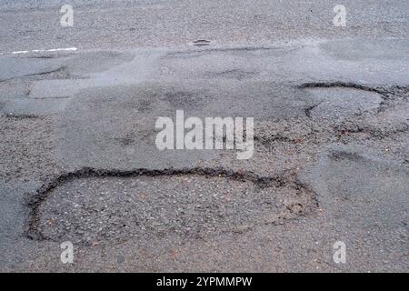 Taplow, Royaume-Uni. 30 novembre 2024. Les nids de poule sont réapparus à Marsh Lane, Taplow, Buckinghamshire. Certains automobilistes font un virage pour les éviter. Les réparations des nids-de-poule précédents sur ce tronçon de route ont été effectuées en mai 2023 par des entrepreneurs du conseil municipal du Buckinghamshire qui ont utilisé un nouveau système Velocity Patching pour remplir les milliers de nids-de-poule à travers Bucks. Le patcher Velocity force l'air à grande vitesse dans les nids de poule pour les éliminer, puis la zone est enduite de bitume froid pour créer un joint, avant que l'agrégat ne soit enduit de bitume et appliqué, à nouveau à grande vitesse. Les réparations n'ont cependant pas été effectuées Banque D'Images