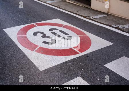 Un panneau de limitation de vitesse peint sur l'asphalte d'une route urbaine indiquant le chiffre trente Banque D'Images